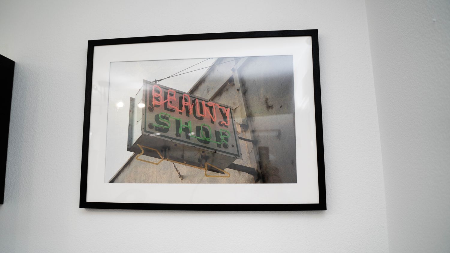 Framed photograph of a beauty shop sign.