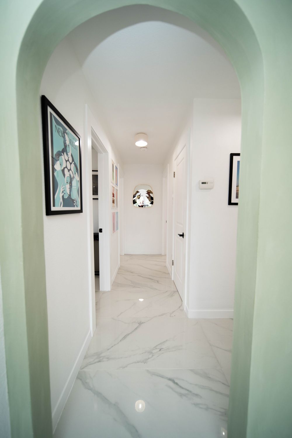 Modern hallway with art and marble flooring.