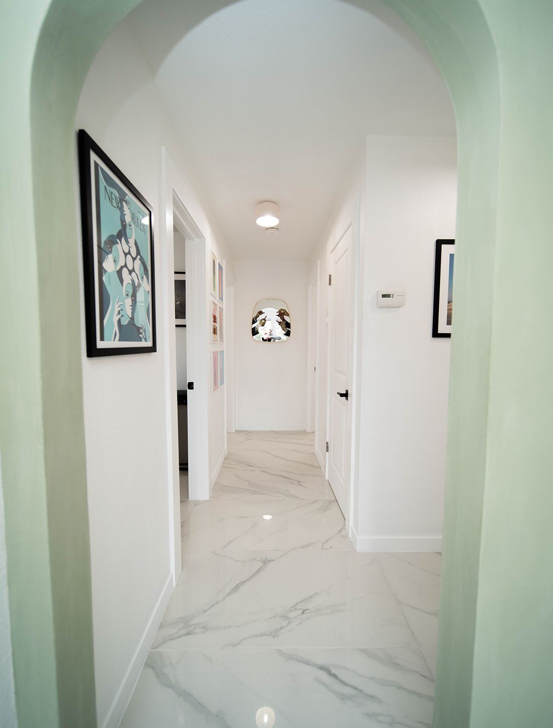 Santa Clara med spa model hallway with marble floor and artwork.