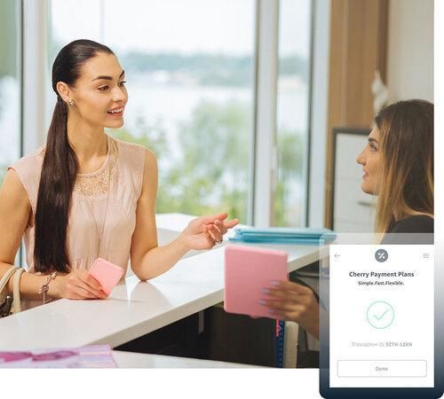 Two women discussing payment plans at a counter.