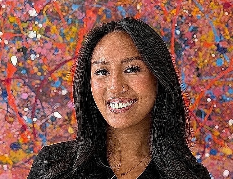 Smiling woman in healthcare attire against colorful background