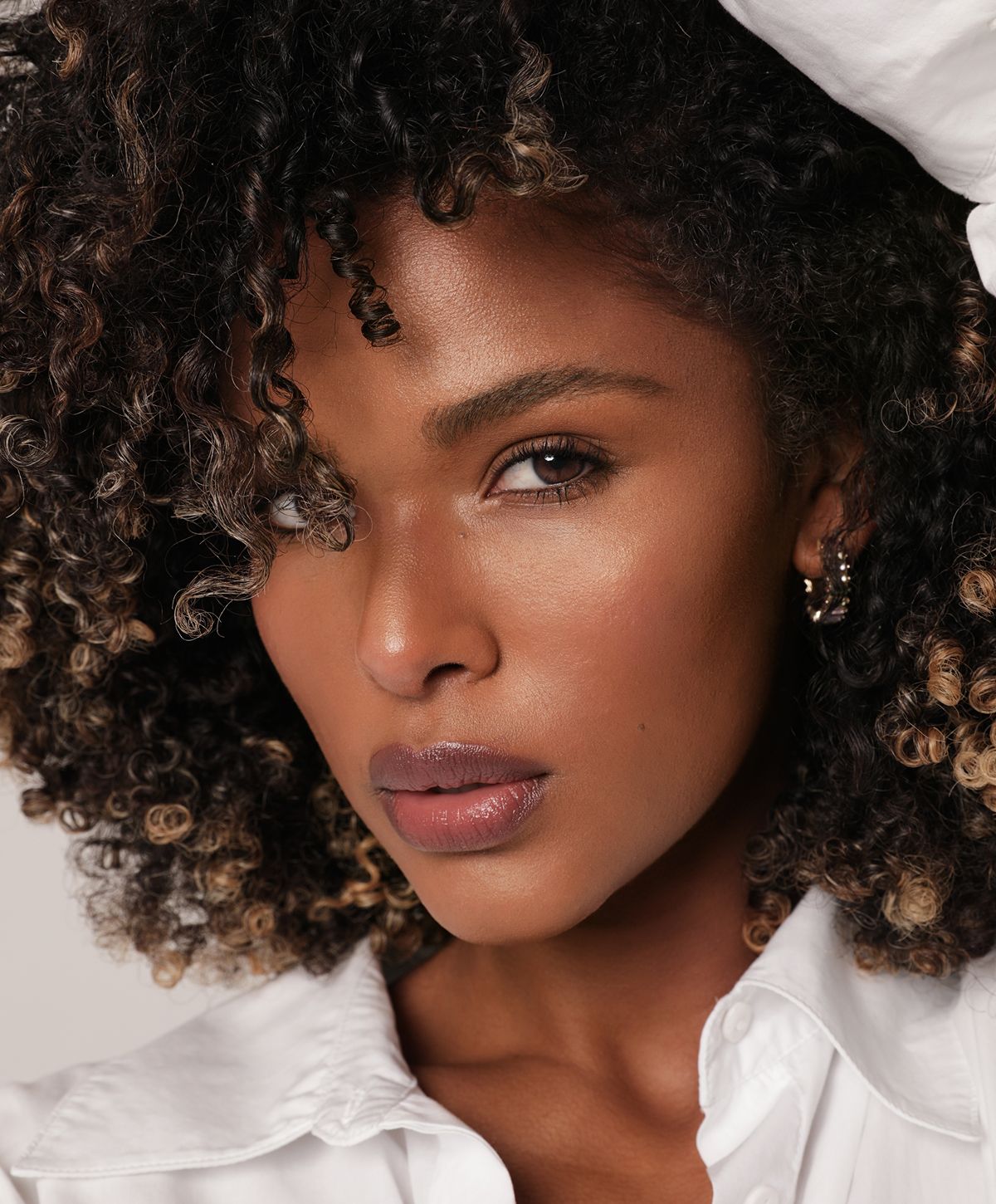 Close-up of a Dysport model with curly hair.