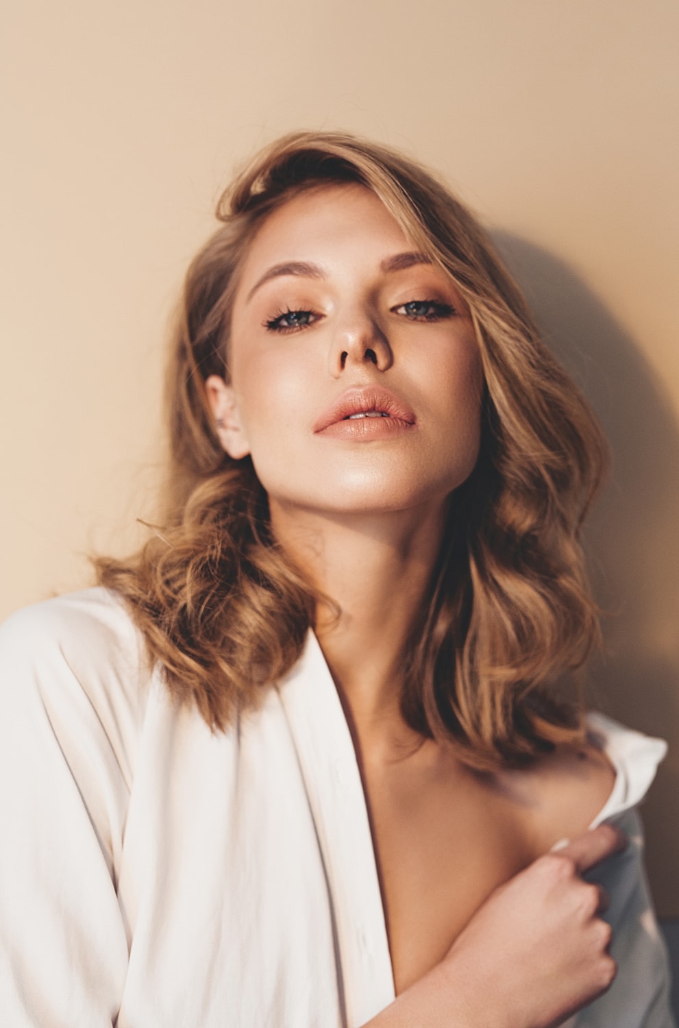 Portrait of a microneedling model with curly hair and earrings.