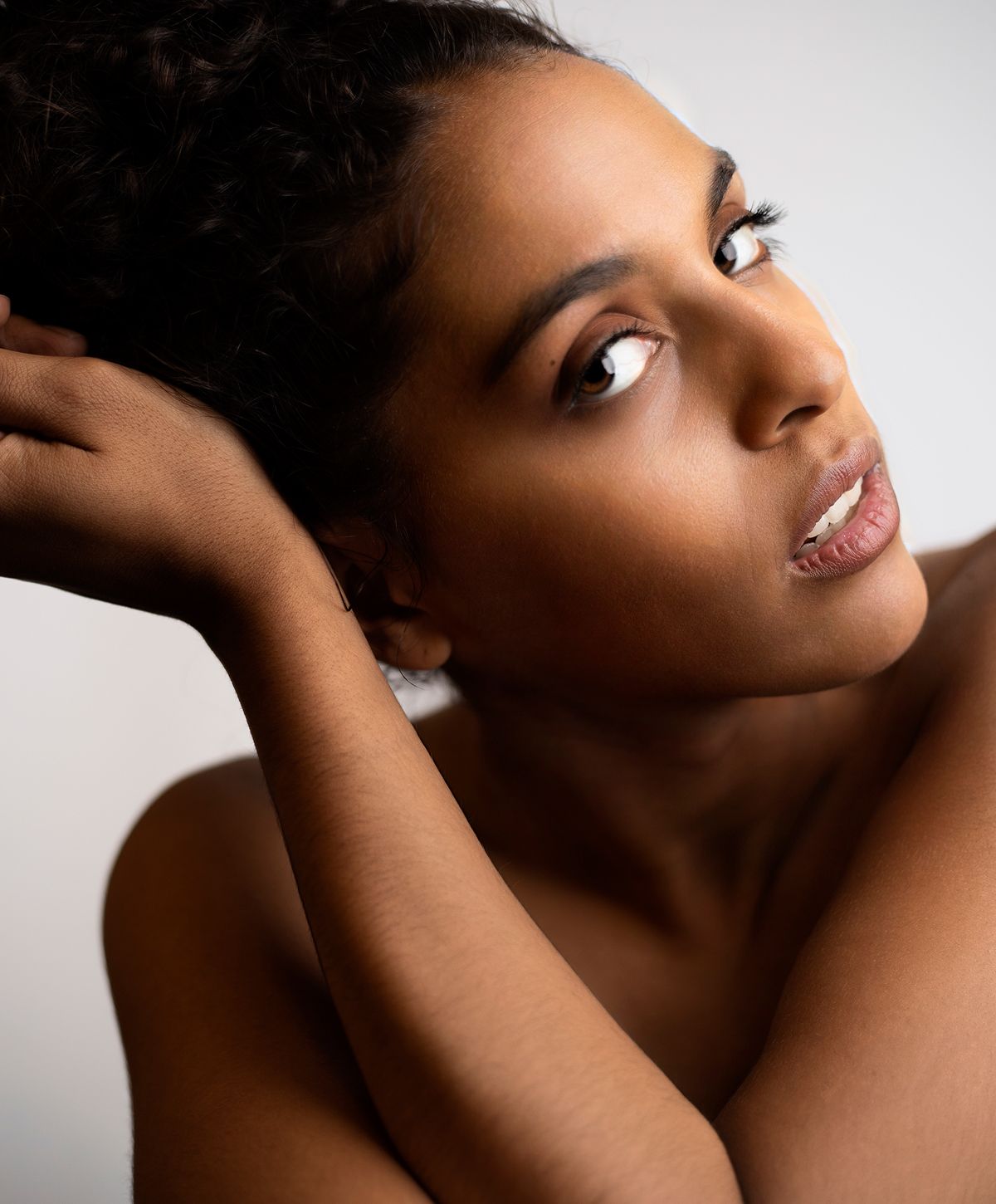 Close-up portrait of a facials model with curled hair.