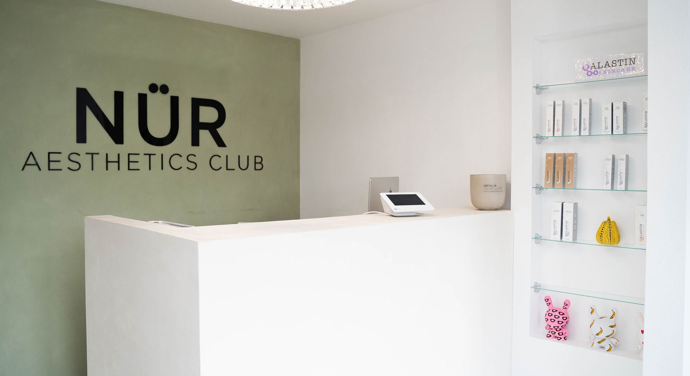 Aesthetic clinic reception with skincare products displayed.