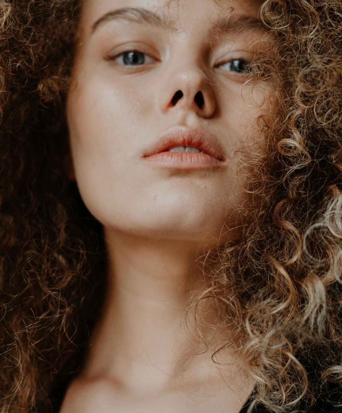 Close-up of a VI Peel model with curly hair.